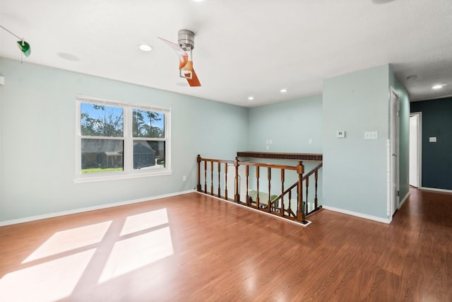 unfurnished room with recessed lighting, wood finished floors, and baseboards