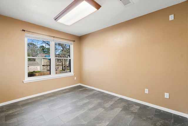 empty room with baseboards and visible vents