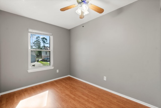 unfurnished room with baseboards, light wood-style flooring, and a ceiling fan