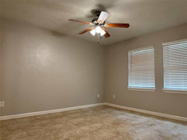 spare room featuring baseboards and ceiling fan