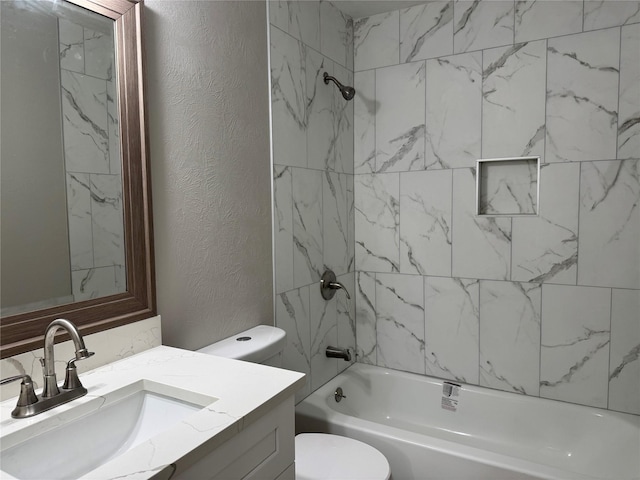 bathroom with vanity, toilet, bathing tub / shower combination, and a textured wall