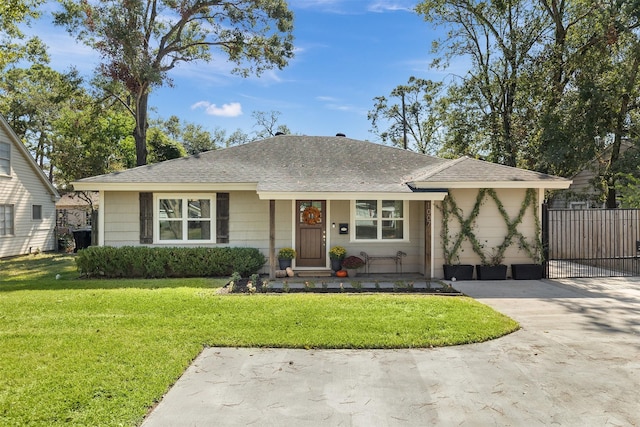 view of front of home featuring driveway, a shingled roof, a front yard, and fence