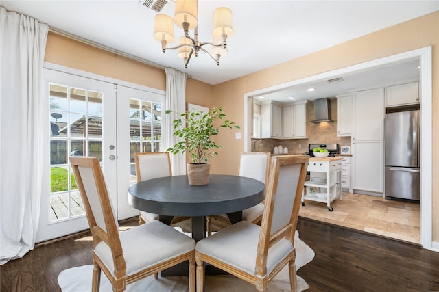 dining space featuring french doors, a healthy amount of sunlight, wood finished floors, and visible vents