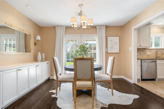 dining area with a chandelier, visible vents, baseboards, and dark wood-style flooring