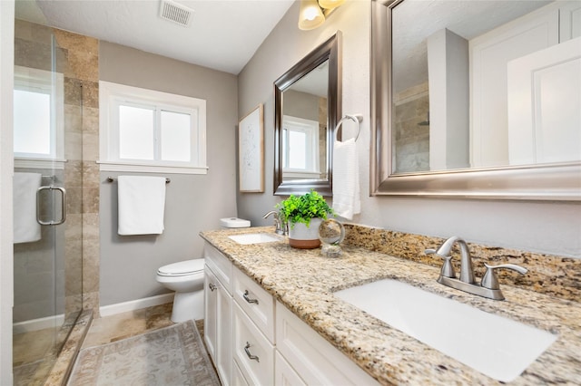 full bath with a shower stall, toilet, visible vents, and a sink