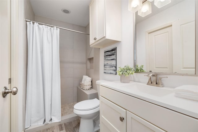 full bathroom with vanity, toilet, wood finished floors, and a stall shower