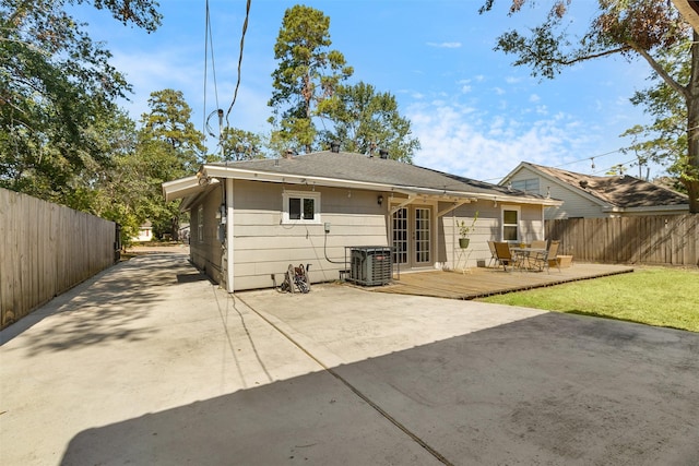 back of house with a wooden deck, a fenced backyard, driveway, and french doors