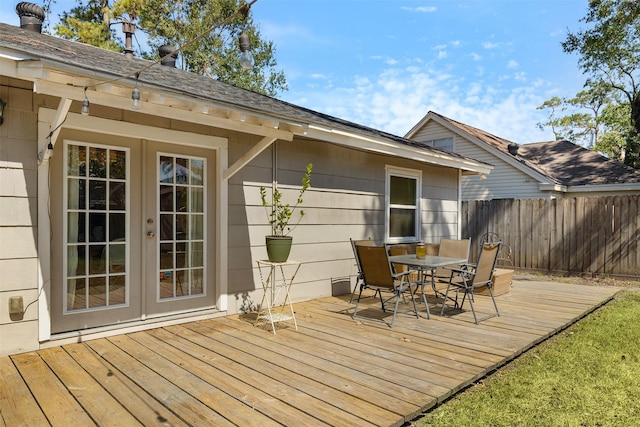 wooden deck with outdoor dining space, french doors, and fence