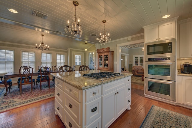 kitchen with an inviting chandelier, crown molding, visible vents, and stainless steel appliances