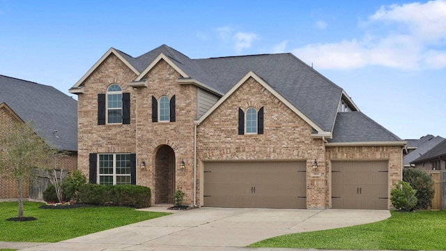 traditional home with brick siding, driveway, a front lawn, and roof with shingles