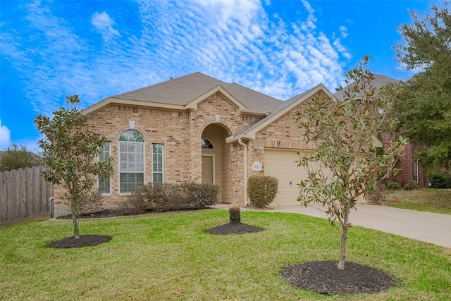 view of front of house featuring fence, an attached garage, a front lawn, concrete driveway, and brick siding