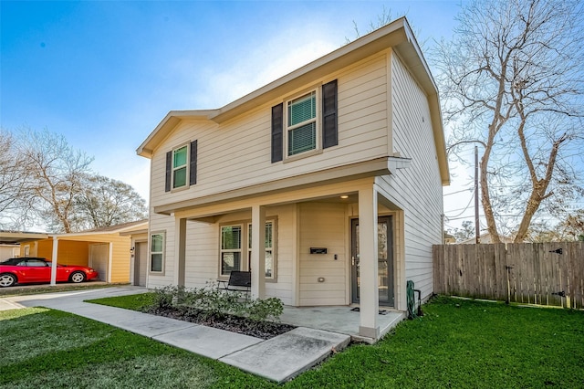 view of front of house featuring covered porch, a front lawn, and fence