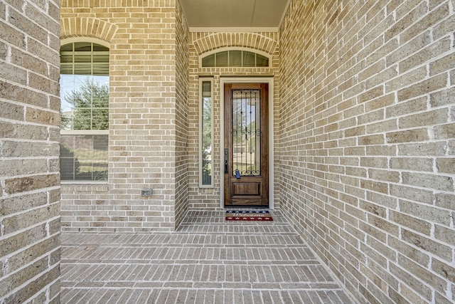 view of exterior entry with brick siding