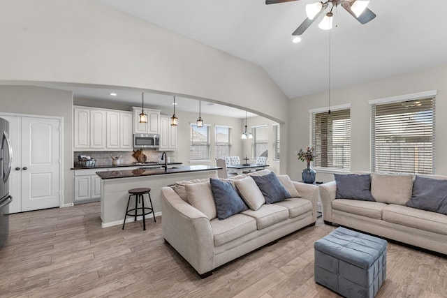 living area featuring recessed lighting, high vaulted ceiling, light wood-style flooring, and a ceiling fan