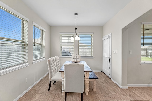 dining space with light wood-type flooring and baseboards