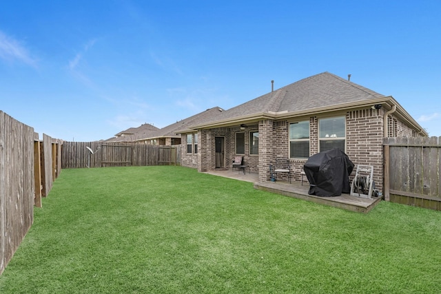 back of house with a patio, a yard, a fenced backyard, and brick siding