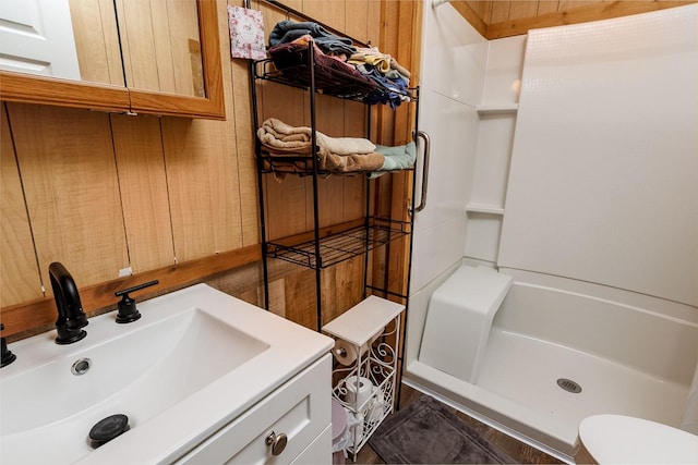 bathroom with toilet, a stall shower, and vanity