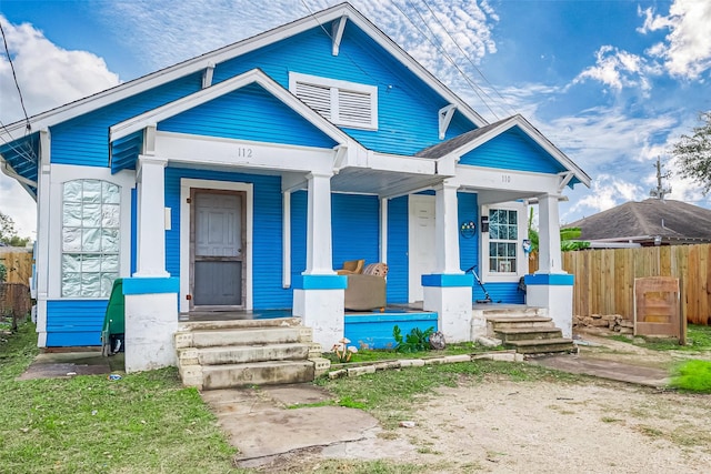 bungalow-style house with a porch and fence