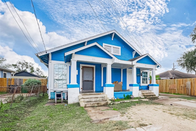 bungalow with covered porch and fence