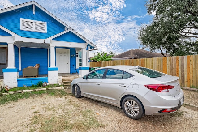 view of front of home with a porch and fence