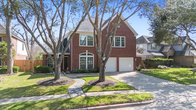 tudor house featuring a front lawn, driveway, fence, an attached garage, and brick siding