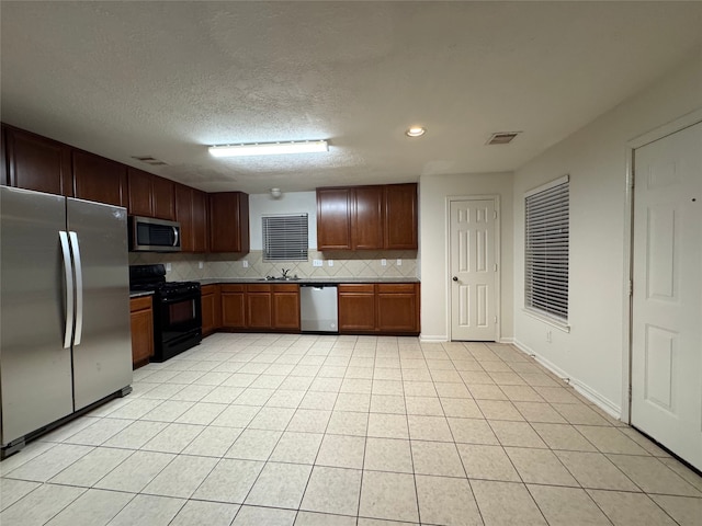 kitchen with a sink, visible vents, backsplash, and appliances with stainless steel finishes