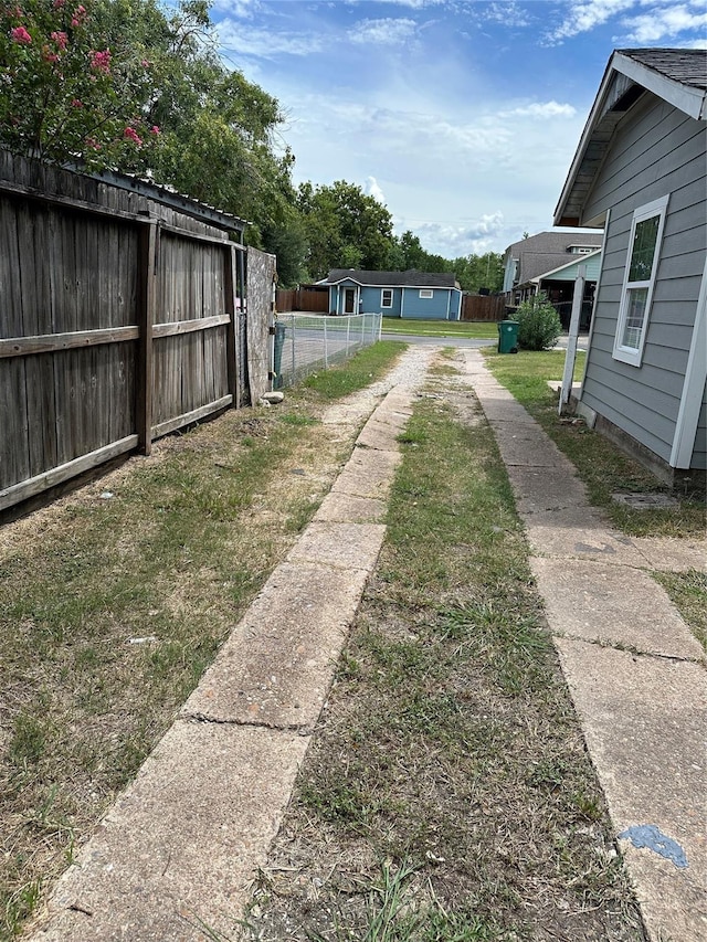 view of yard featuring driveway and fence