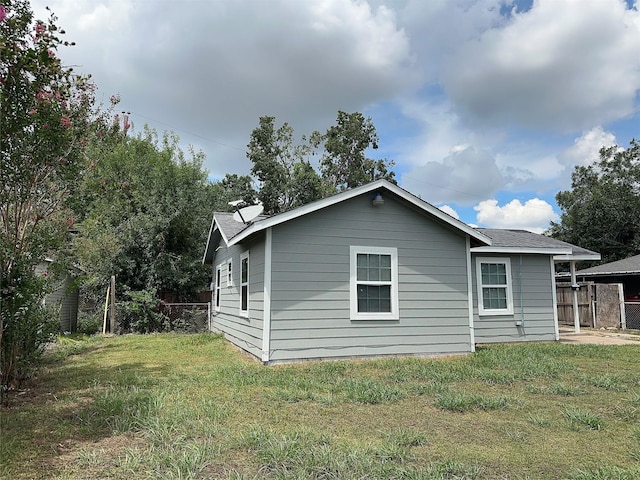 view of home's exterior with a yard and fence