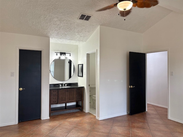 bathroom featuring visible vents, toilet, baseboards, lofted ceiling, and vanity