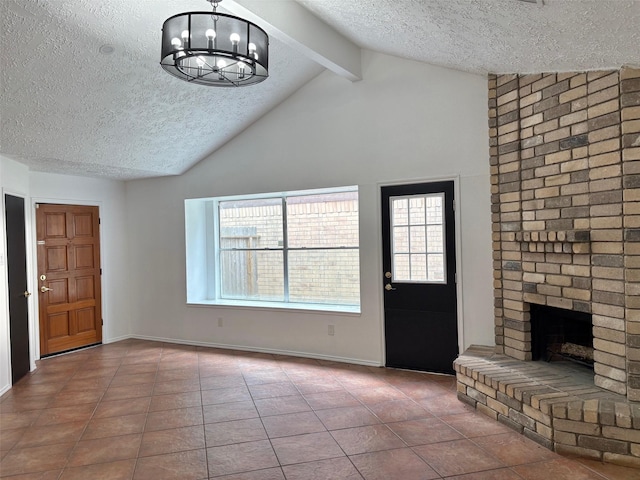 tiled entryway featuring a notable chandelier, a brick fireplace, vaulted ceiling with beams, and a textured ceiling