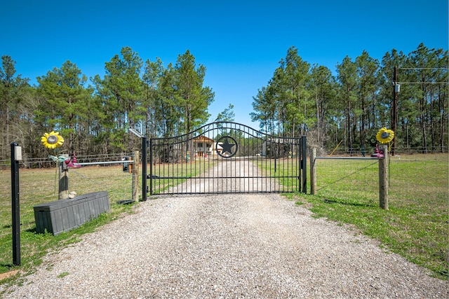 view of gate with a yard and fence