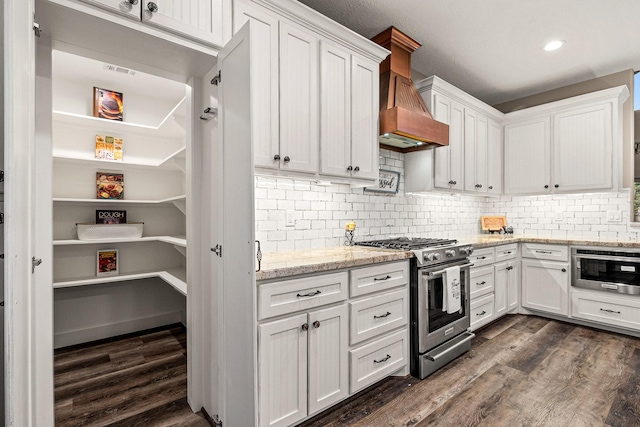 kitchen with white cabinetry, stainless steel range with gas stovetop, dark wood-style flooring, and custom range hood