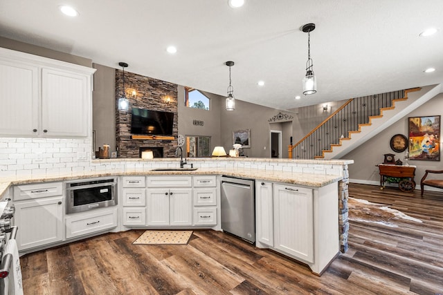 kitchen featuring dark wood finished floors, a peninsula, a sink, white cabinets, and dishwasher