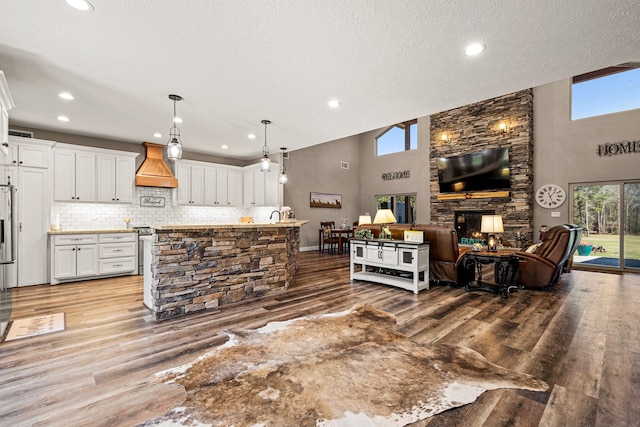 living area featuring recessed lighting, a textured ceiling, a high ceiling, and wood finished floors