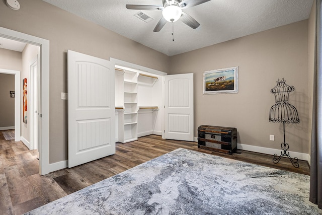 bedroom featuring wood finished floors, baseboards, ceiling fan, a closet, and a textured ceiling