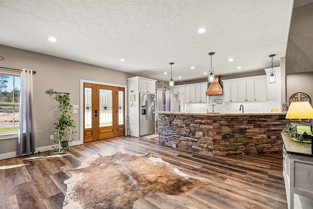 kitchen with dark wood finished floors, white cabinets, high quality fridge, and tasteful backsplash