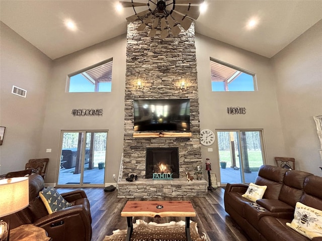 living room featuring visible vents, a fireplace, baseboards, and dark wood-style flooring