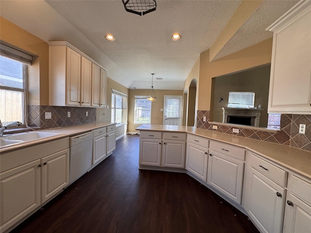 kitchen with dark wood-style flooring, dishwasher, light countertops, and a sink