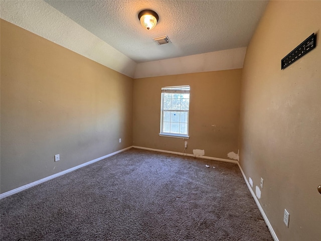 spare room with visible vents, baseboards, carpet, lofted ceiling, and a textured ceiling