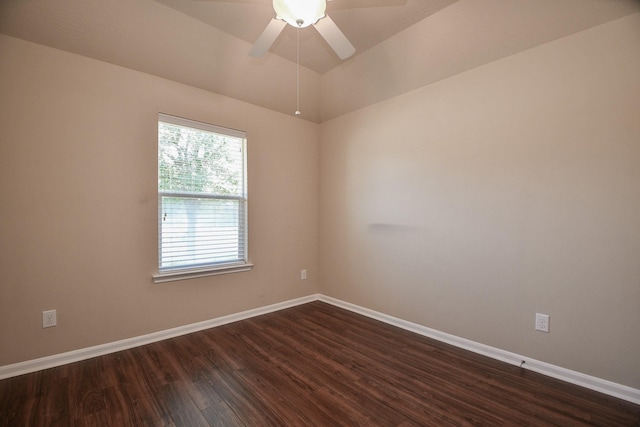 unfurnished room featuring dark wood finished floors, a ceiling fan, and baseboards