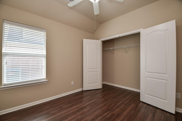 unfurnished bedroom with ceiling fan, baseboards, vaulted ceiling, a closet, and dark wood-style flooring