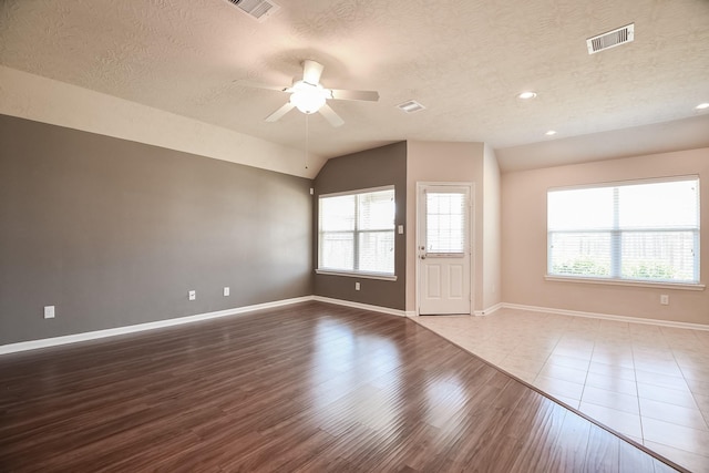 spare room featuring visible vents, wood finished floors, and vaulted ceiling