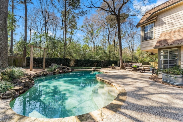 view of pool with an outdoor living space, a patio, a fenced backyard, and a fenced in pool