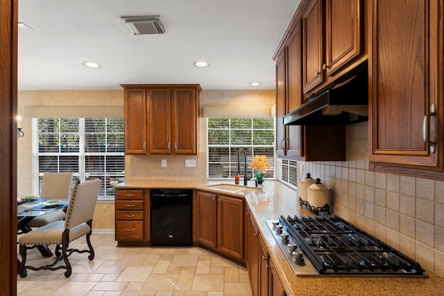 kitchen featuring visible vents, under cabinet range hood, a sink, plenty of natural light, and stainless steel gas stovetop