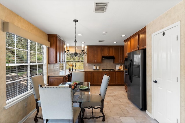 dining space with visible vents, stone finish flooring, recessed lighting, an inviting chandelier, and baseboards