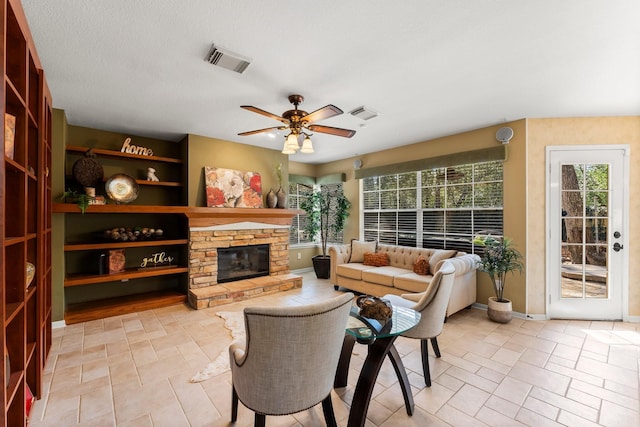 interior space with visible vents, baseboards, ceiling fan, and a fireplace