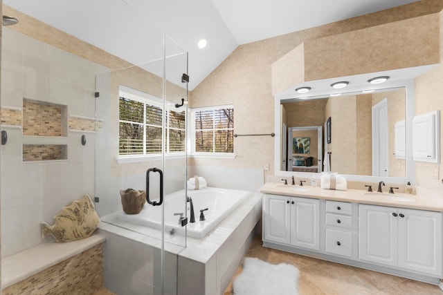 full bath with double vanity, vaulted ceiling, a stall shower, and a sink