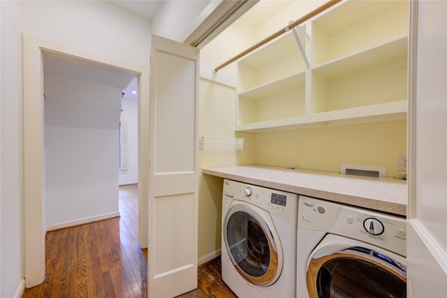 laundry room featuring laundry area, washing machine and dryer, baseboards, and wood finished floors