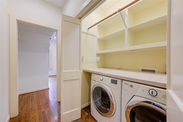 clothes washing area featuring baseboards, wood finished floors, washer and dryer, and laundry area