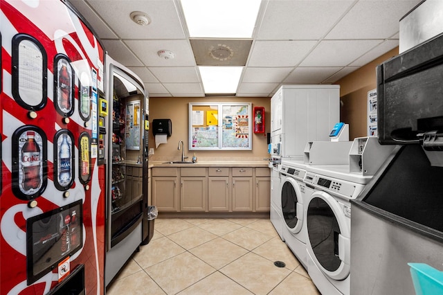 laundry room featuring washing machine and clothes dryer, stacked washer / dryer, light tile patterned floors, cabinet space, and a sink